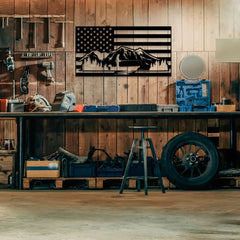 A rugged metal american flag wall panel with mountains and forest silhouettes decorates a rustic workshop wall, blending strength and nature in durable patriotic wall decor.