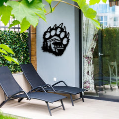 A striking metal art for outdoors piece shaped like a bear paw with a mountain scene brings a bold rustic accent to a modern patio wall.