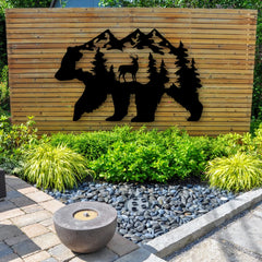 A layered metal artwork for the garden featuring a bear, deer, and mountains adds a wild, storytelling element to a modern backyard.