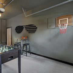 Oversized sunglasses with an American flag design in black metal add playful, patriotic energy to this modern game room wall.