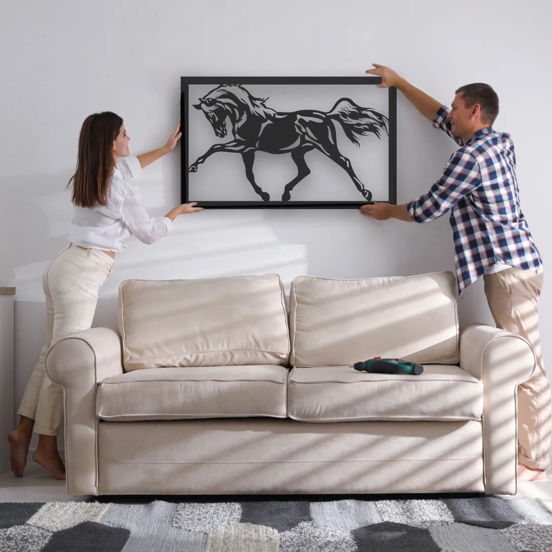 A bold black steel wall art piece featuring a rearing horse being installed above a beige couch, adding movement and character to this cozy living room.
