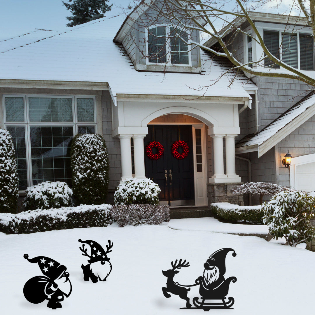 Three playful metal garden gnome decorations, including reindeer and sleigh designs, add holiday spirit to a snow-covered front lawn.