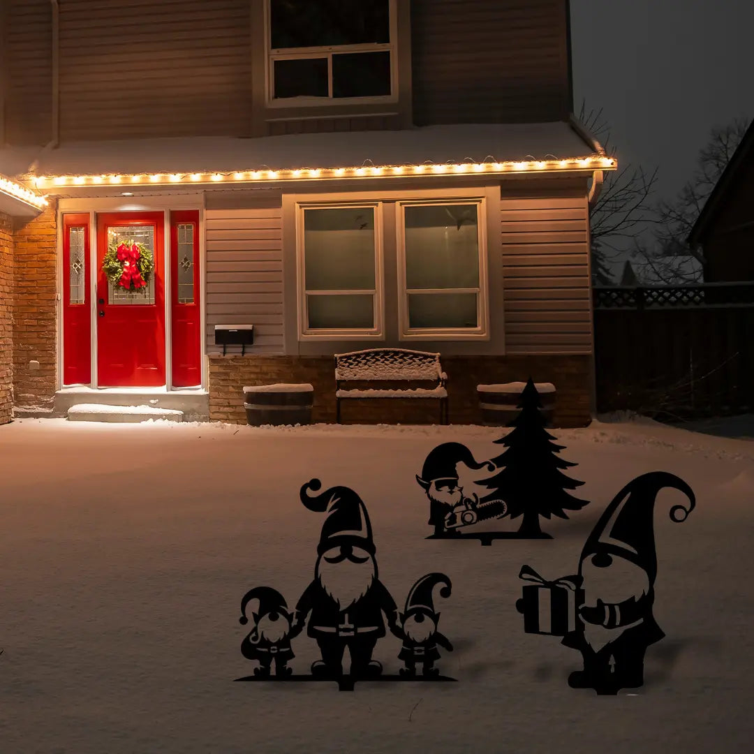 A charming winter lawn display with festive yard gnomes and Christmas props in black metal silhouette style adds whimsy to a snow-covered home exterior.