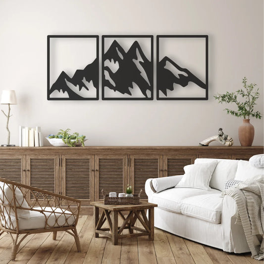A clean mountain wall art triptych in black steel serves as a striking focal point above a rustic wooden sideboard in a cozy living room.
