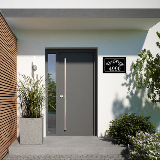 A modern rectangular address plaques for yard piece with clean mountain outlines and house number mounted beside a sleek gray door adds a nature-inspired accent.