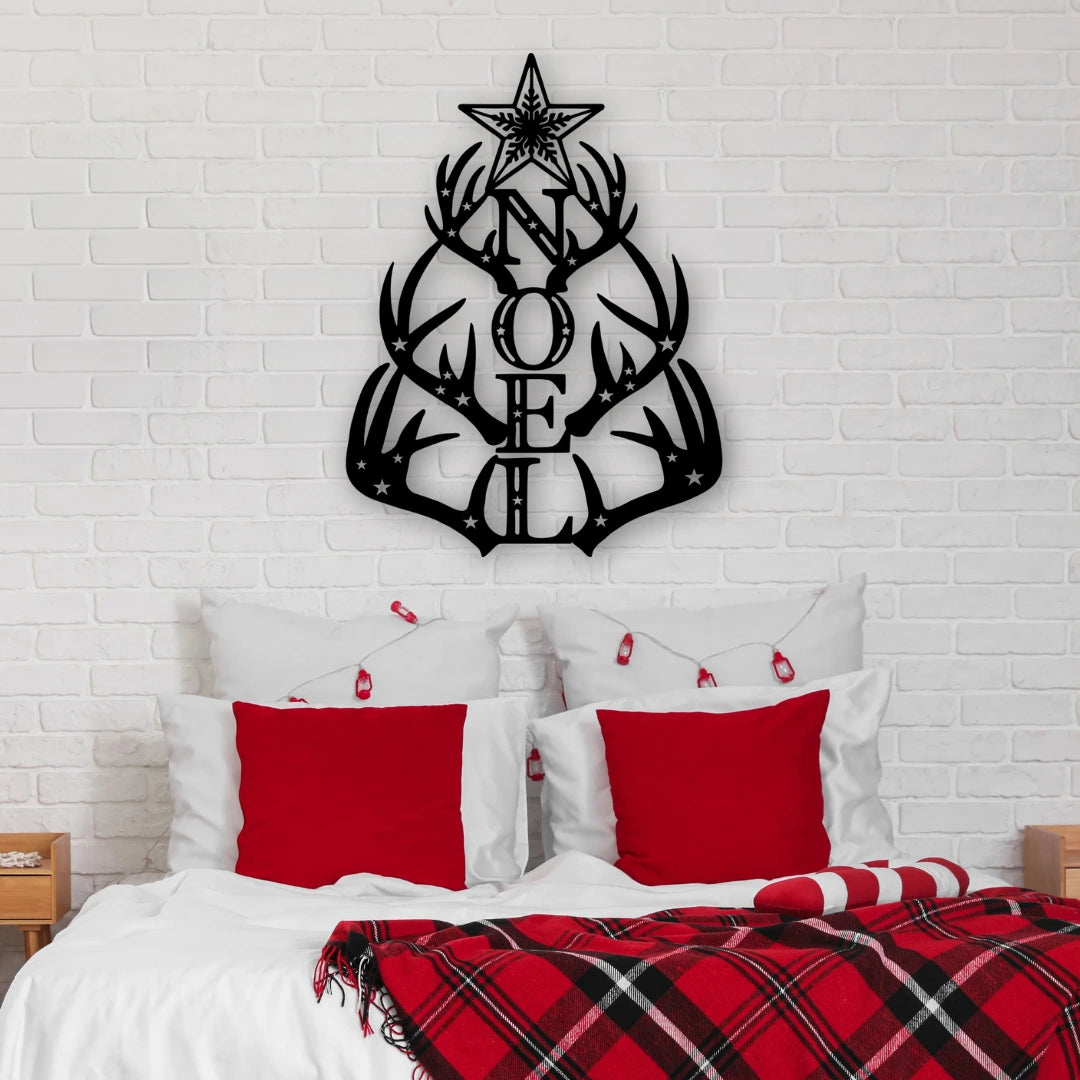 A holiday metal deer sign shaped like antlers spelling “NOEL” sits above a red-accented bed, making this piece a bold and rustic metal christmas signs option for the bedroom.