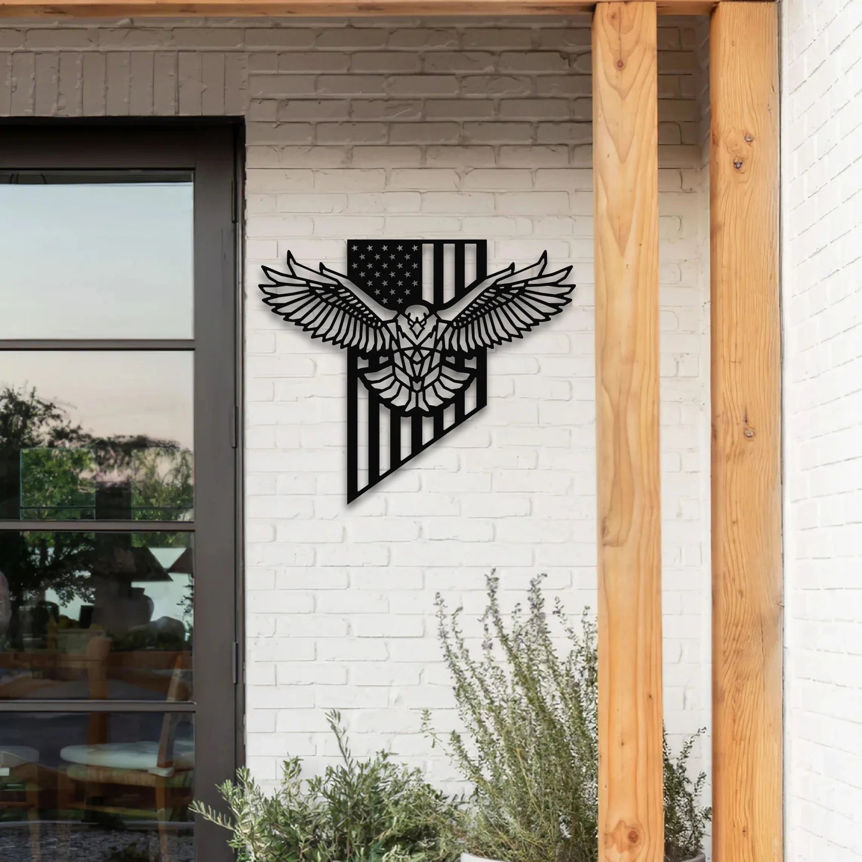 A detailed bald eagle flag metal artwork featuring the American flag and eagle silhouette, mounted on a white brick wall beside a patio entrance.
