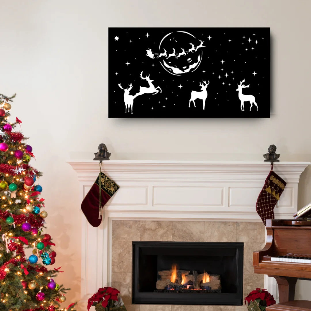 Festive metal wall art showing Santa and his sleigh flying across the moonlit sky with reindeer, displayed above a white mantel in a holiday-decorated living room.
