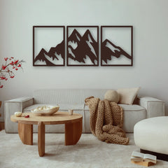 A serene mountain triptych made of black steel anchors the space, offering modern charm and a nature-inspired focal point in this warm, neutral-toned living room.
