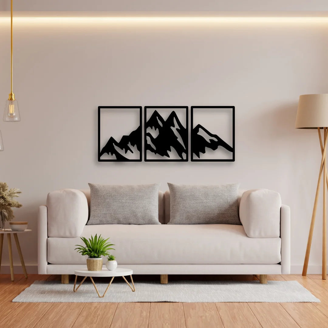 A minimalist metal mountain wall art triptych with sharp black peaks, offering a clean, nature-inspired look above the modern sofa.
