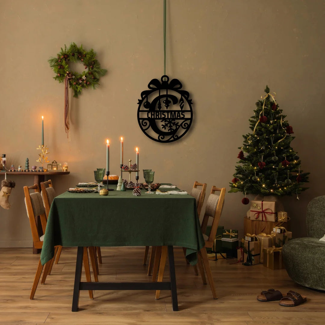 A festive christmas tree wall art sign shaped like a classic ornament, elegantly completes this holiday dining setup with timeless seasonal charm.
