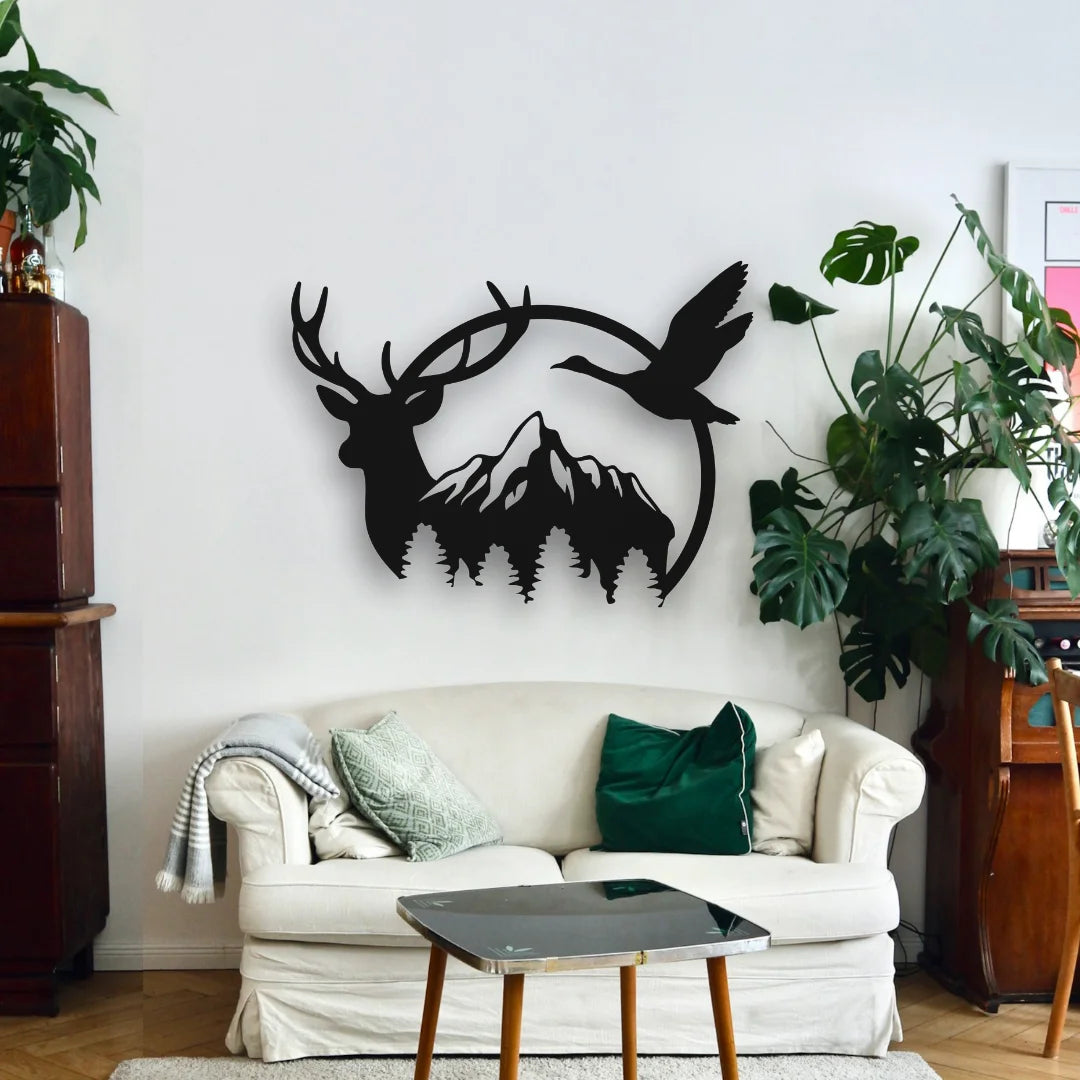 A black circular custom deer and mountain wall art decor adds a sense of wilderness above a white sofa in a modern living room filled with natural accents.
