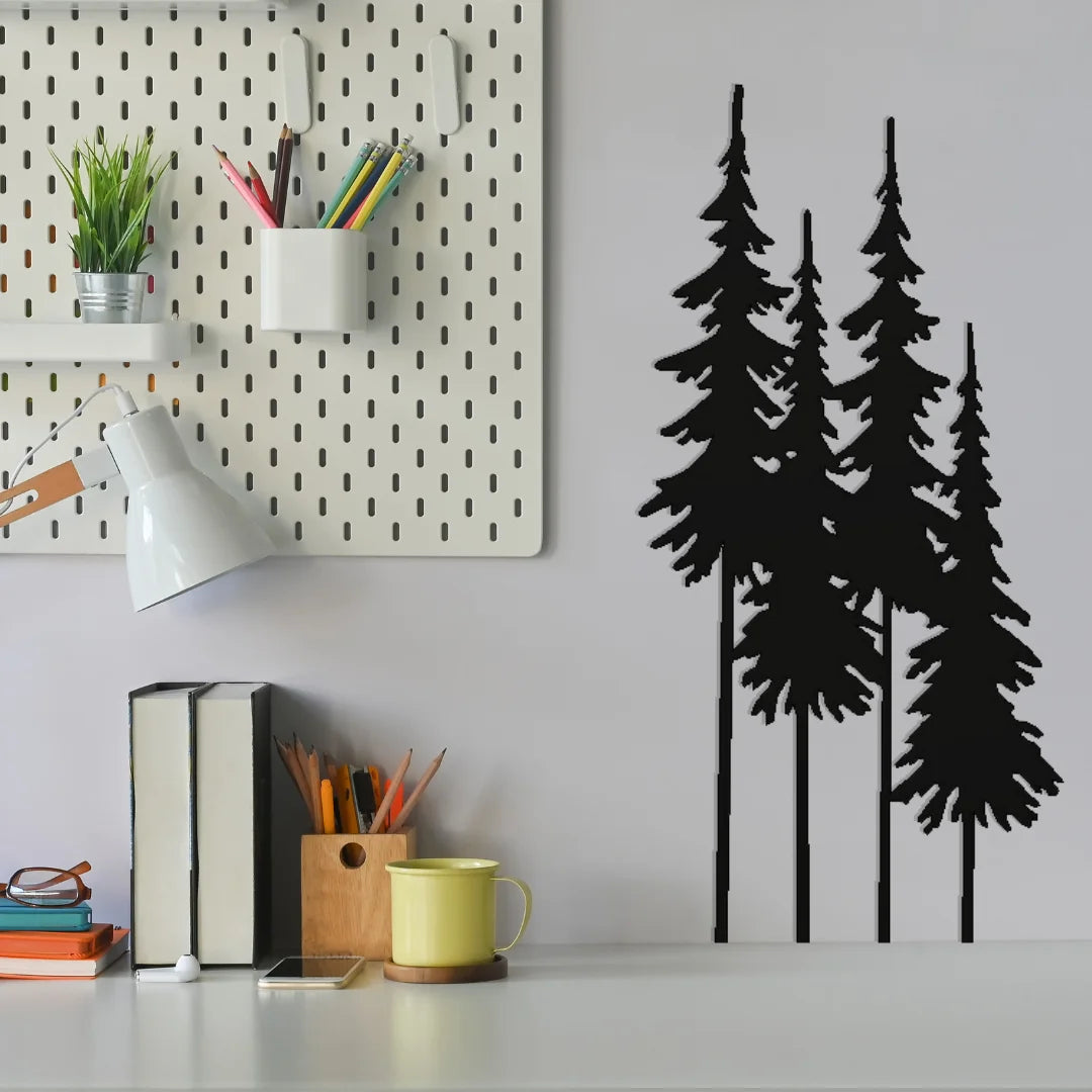 Four slender pine trees in metal wall art style offer a vertical accent near a modern desk setup, blending nature and functionality for forest lovers.
