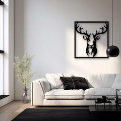 A bold framed metal wall art piece depicting a deer’s head in silhouette adds contrast and drama to a minimalist living room with a white sofa and black accents.
