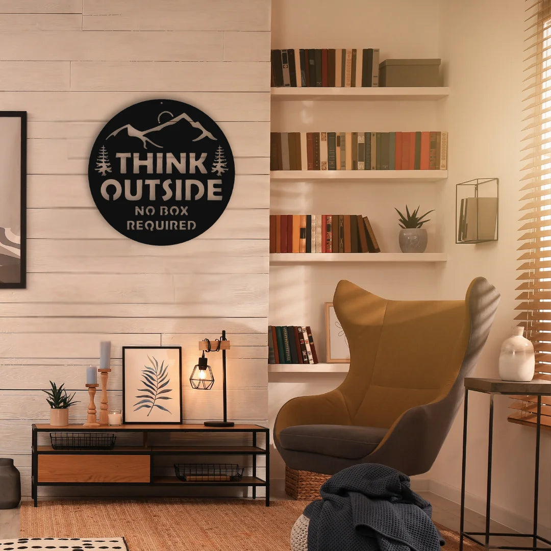 A matte black decorative metal sign with mountain silhouette and bold message enhances a rustic reading space with warm tones and natural wood details.

