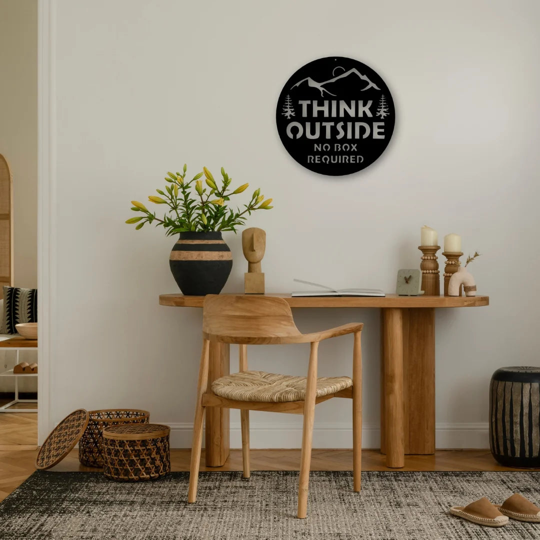 An inspirational metal words wall decor sign encourages creativity with the message “Think Outside—No Box Required.”
